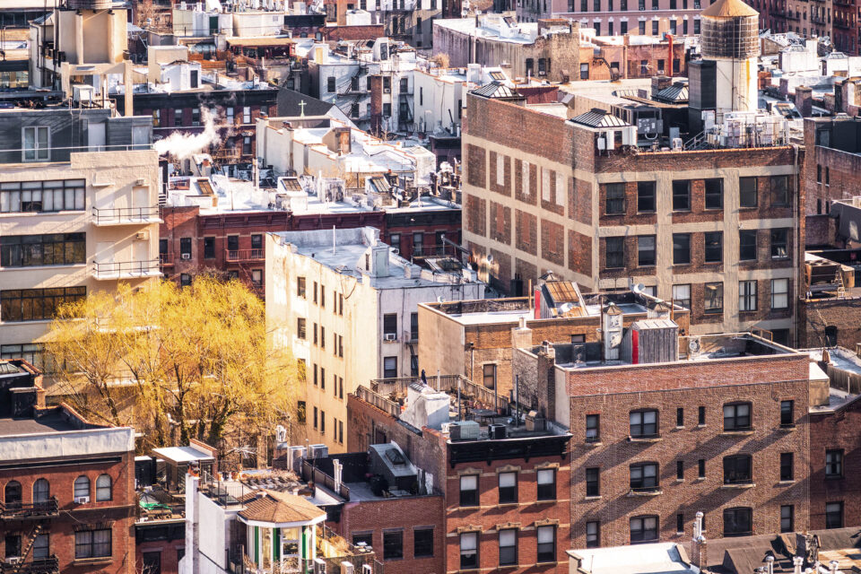A view over the Hell's Kitchen and Midtown districts of Manhattan, New York City with the streets mostly taken up by traditional brick apartment buildings.