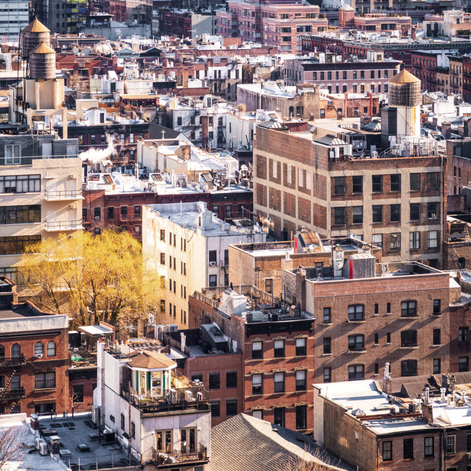 A view over the Hell's Kitchen and Midtown districts of Manhattan, New York City with the streets mostly taken up by traditional brick apartment buildings.