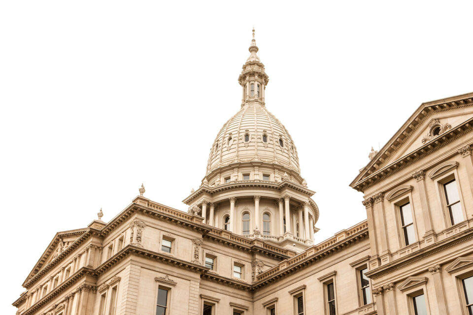 Daylight horizontal view of Michigan State capitol building in Lansing, MI isolated on white sky